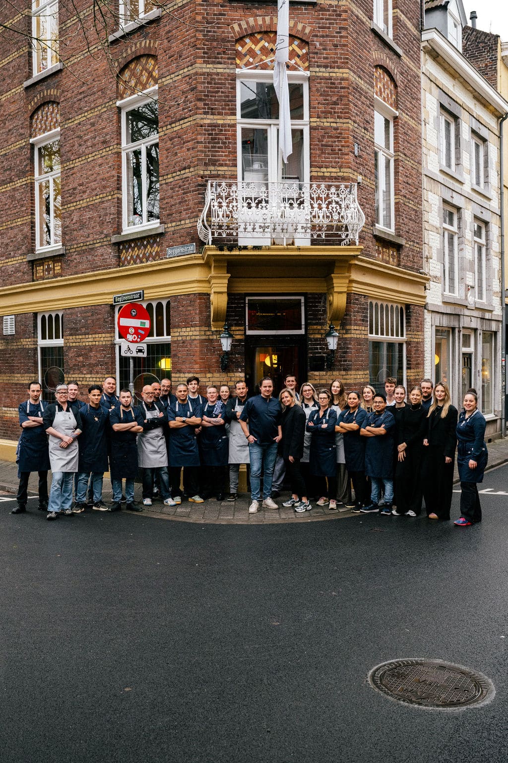 Het hoekpand van Café Sjiek in de Sint Pieterstraat, met het voltallige team in schorten voor de deur